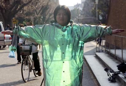 Is he 'The Invisible Man' by H.G. Wells? It looks like as if three men walking behind are seen through the body of graduate student Kazutoshi Obana during a demonstration of optical camouflage technology at the Tokyo University in Tokyo Wednesday, Feb. 5, 2003. The demonstration conducted by Faculty of Engineering Prof. Susumu Tachi is an early stage of his research that will eventually enable camouflaged objects virtually transparent by wearing an optical device. This photo was taken through a viewfinder that provides with a combined image of moving images taken behind Obana and him wearing a luminous jacket that makes a transparent effect. The technology can be useful for various professions such as surgeons who wish their own fingers and surgical tools won't block the view of affected parts and pilots who wish cockpit floors were transparent for landings. (AP Photo/Shizuo Kambayashi)